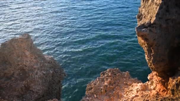 Rivage rocheux de la mer avec des vagues sur le fond. Journée ensoleillée à Bali, Indonésie . — Video