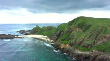 Güneşli bir günde okyanus manzarası ve yeşil kayalık tepeler. Lombok, Endonezya.