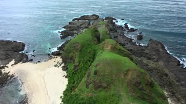 Повітряний вид мальовничого пейзажу з океанічними та зеленими скелястими пагорбами в сонячний день. Ломбок, Індонезія. — стокове відео