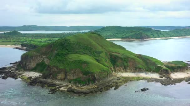 Letecký pohled na malebnou krajinu s oceánem a zelenými skalnatými kopci během slunečného dne. Lombok, Indonésie. — Stock video