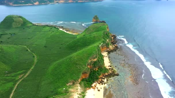 Légi kilátás festői táj óceán és zöld sziklás dombok a napsütéses napon. Lombok, Indonézia. — Stock videók