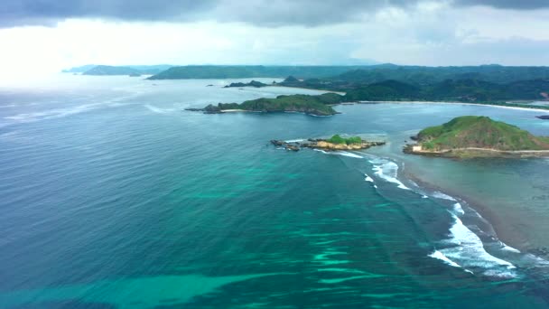 Letecký pohled na malebnou krajinu s oceánem a zelenými skalnatými kopci během slunečného dne. Lombok, Indonésie. — Stock video