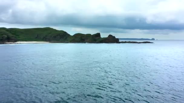 晴れた日の間に海と緑の岩の丘と風光明媚な風景の空中ビュー。インドネシアのロンボク. — ストック動画