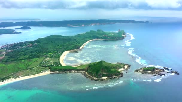 晴れた日の間に海と緑の岩の丘と風光明媚な風景の空中ビュー。インドネシアのロンボク. — ストック動画