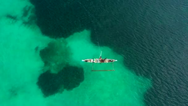 Vista aérea de arriba hacia abajo del pescador poniendo sus redes de pesca al mar con agua clara y azul . — Vídeo de stock