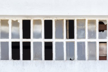 Beyaz bir duvar üzerinde kırık pencere