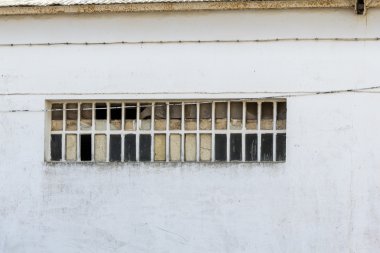Beyaz bir duvar üzerinde kırık pencere
