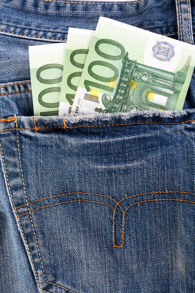 Banknotes hundred euro sticking out of the back jeans pocket.