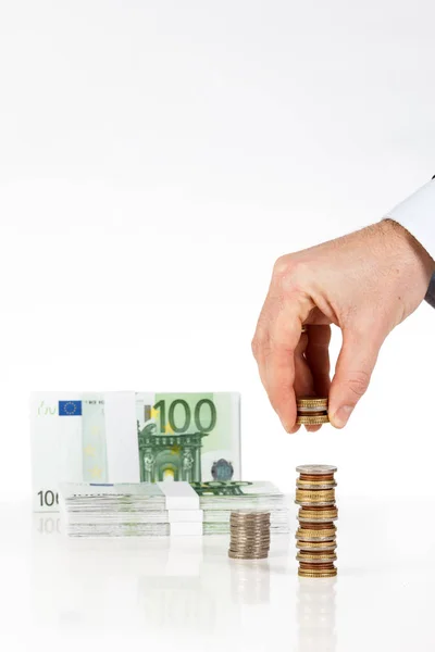 Manlig hand stapling mynt med eurosedlar på bakgrund — Stockfoto