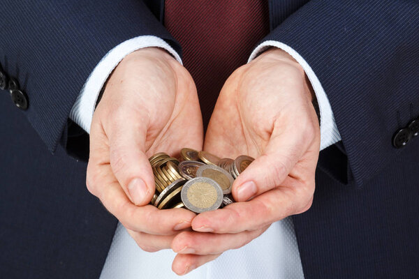 Businessman hands holding a pile of euro coins