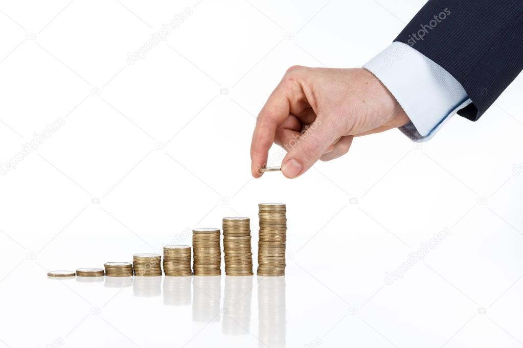 Close up of businessman hand stacking one euro coins into increa