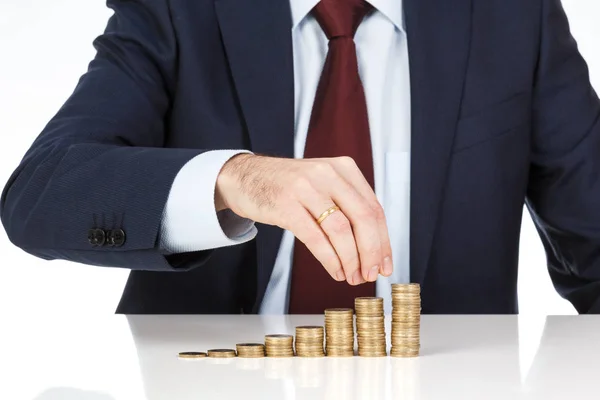 İşadamı el yığın bir euro sikke sütun artan içine