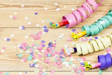 ahşap zemin üzerine konfeti, flamalar ve parti blower