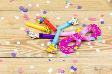 ahşap zemin üzerine konfeti, maske ve parti üfleyiciler