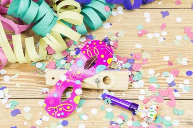 ahşap zemin üzerine konfeti, flamalar, maske ve parti blower