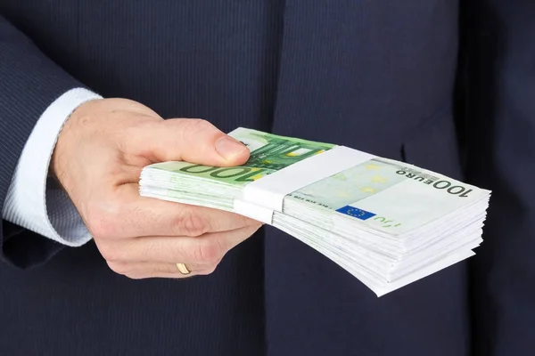 Деловой человек держит в руках деньги, банкноты евро . — стоковое фото