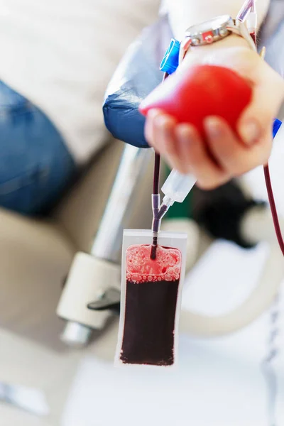 Joven mujer caucásica con corazón de juguete en la mano dona sangre para salvar vidas e investigación médica — Foto de Stock