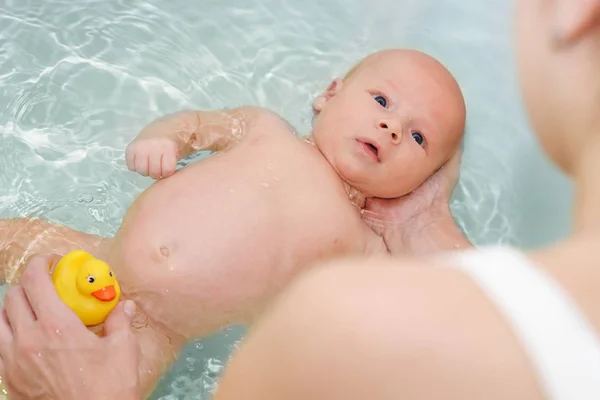 백인 여자 목욕 그 동안 물에 그녀의 갓난 아기를 들고 있다 — 스톡 사진