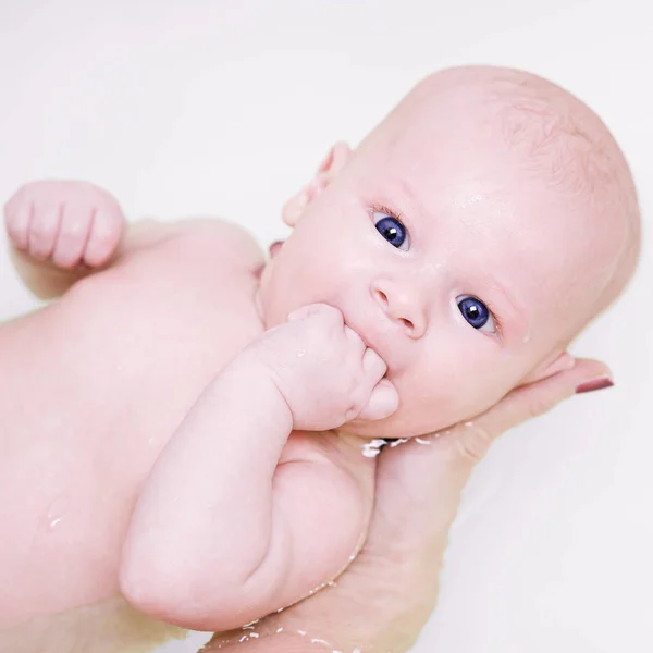Caucasian woman is holding her newborn baby on the water while he bathing — Stock Photo, Image