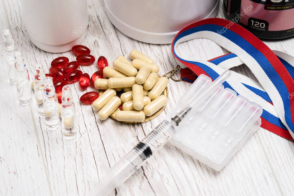 tablets, pills and syringe of doping drugs or medicine with russ