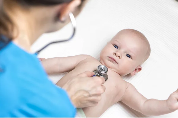 bir beyaz kadın doktor stetoskop randevu tarafından bebek çocuk kalp atışı dinleme