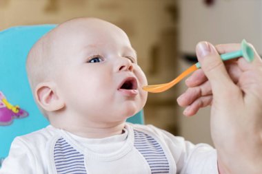 Anne yayınlarını kaşık tarafından duygusal bir bebek çocuk mavi gözleriyle gün anda