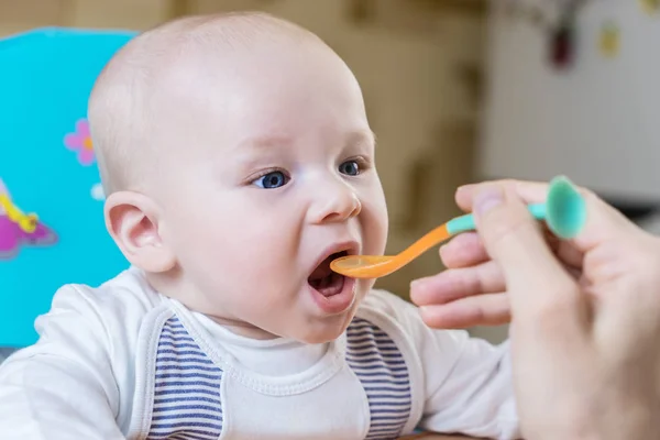 Anne yayınlarını kaşık tarafından duygusal bir bebek çocuk mavi gözleriyle gün anda