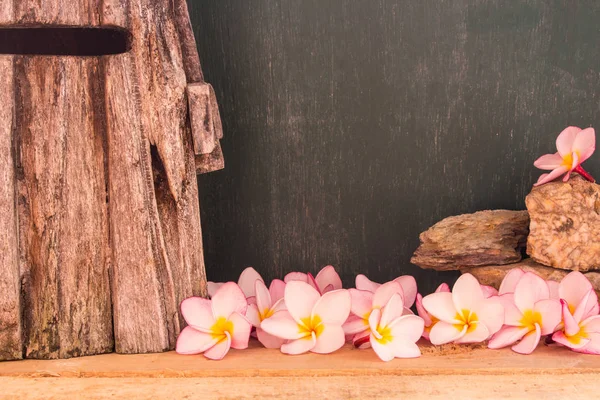 Plumeria bazı fikir için tahta yel değirmeni ve kara tahta arka plan ile