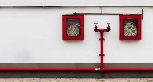 Armoire de tuyau d'incendie sur le mur blanc avec beaucoup d'espace de copie Photo De Stock