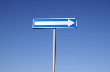 Tek yön işareti mavi gökyüzü arka plan