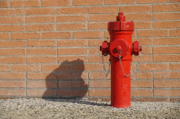 Hydrant and old brick wall in front of factory