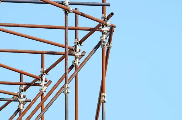 Andaimes de metal na construção e fundo céu azul — Fotografia de Stock