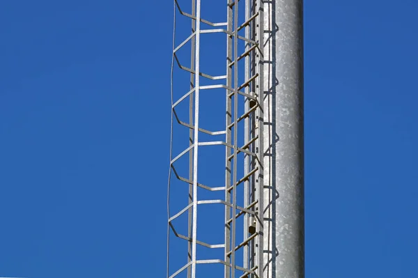 Industriële verticale trap met blauwe hemelachtergrond met een hoog contrast — Stockfoto