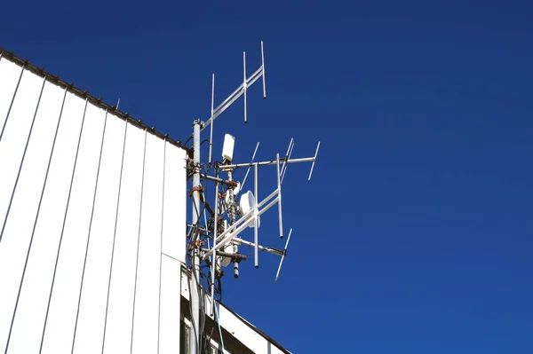 Torres de telecomunicaciones con antenas de TV y antenas parabólicas en cielo azul claro —  Fotos de Stock
