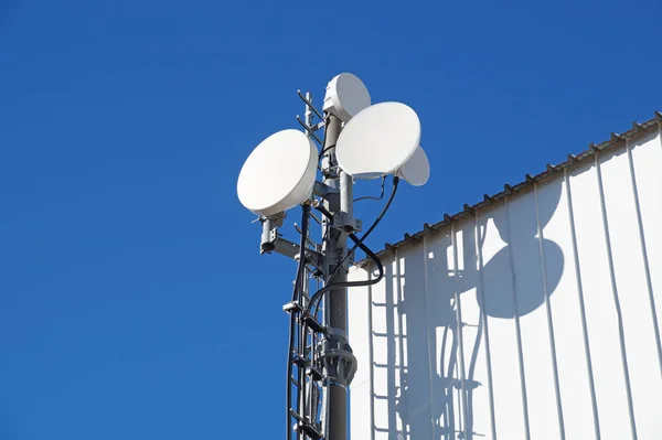 Tours de télécommunication avec antennes TV et antenne parabolique sur ciel bleu clair — Photo