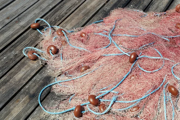 Redes de pesca de corda laranja em um cais de madeira  . — Fotografia de Stock
