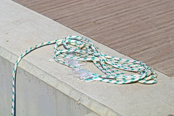 Ligne d'amarrage enroulée attachée autour du crampon sur un quai en bois . — Photo