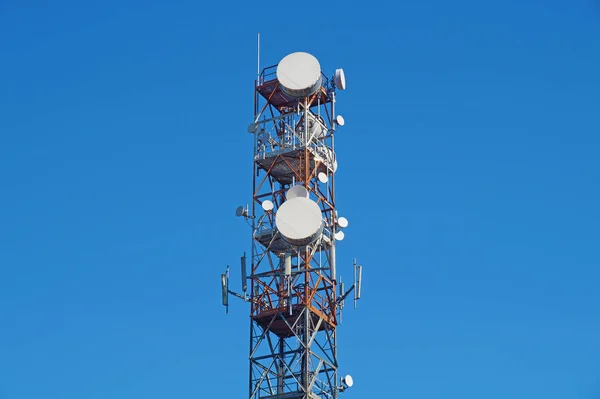 Телекоммуникационная башня с антеннами голубого неба — стоковое фото