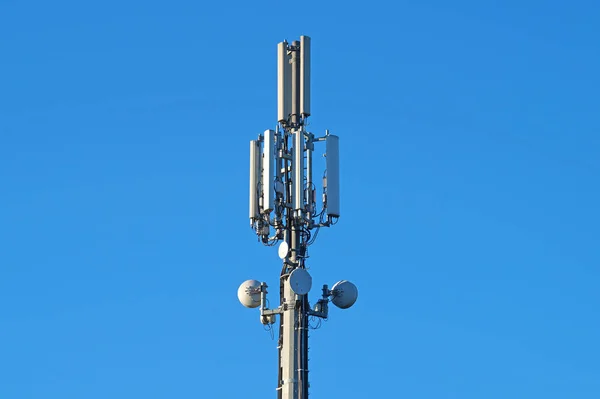 Modern Cellular Tower - Communication  on Blue Sky. Vertical Photography.