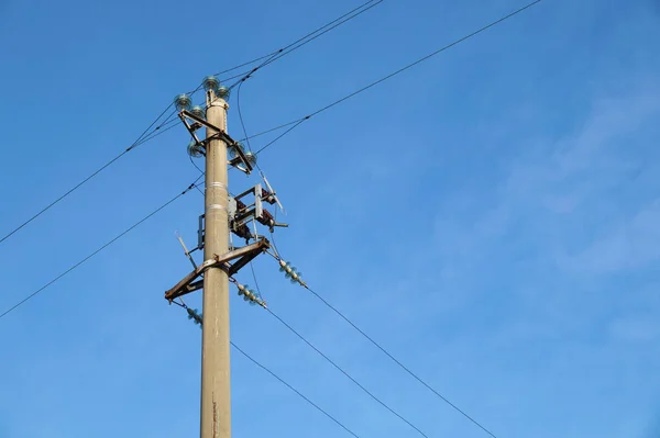 大きな金属電柱メインで青い空を背景に高圧送電線が交差します。. — ストック写真