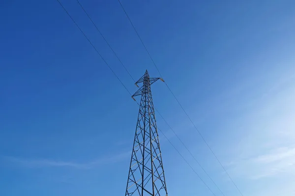 Elektrische palen van hoogspanning in witte wolk en blauwe hemel — Stockfoto