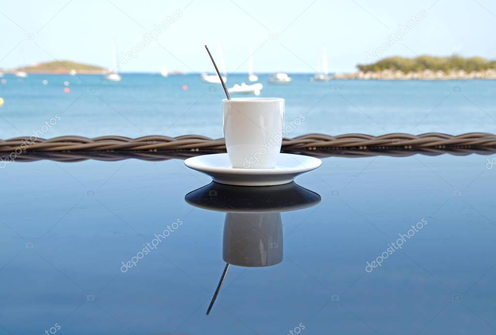 Close up Coffee cup on wood table . View of tropical beach