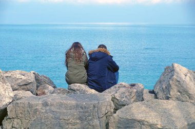 ufuk izlerken kayaların üzerinde oturan insanlar