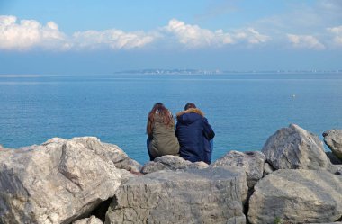 ufuk izlerken kayaların üzerinde oturan insanlar