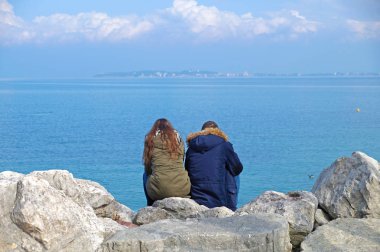 ufuk izlerken kayaların üzerinde oturan insanlar
