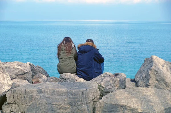 ufuk izlerken kayaların üzerinde oturan insanlar