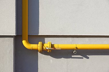 Konut bina duvar önünde sarı gaz borusu