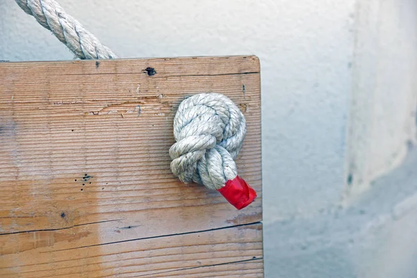 Touw met knopen op de achtergrond van de oude houten planken — Stockfoto