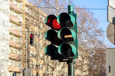 Mavi gökyüzü ve şehirler arka planlar önünde kırmızı ve yeşil trafik ışığı
