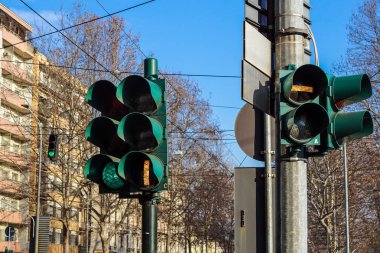 Mavi gökyüzü ve şehirler arka planlar önünde kırmızı ve yeşil trafik ışığı